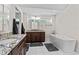 Modern bathroom with double sinks, granite countertops, and a soaking tub at 170 Sw 80Th St, Ocala, FL 34476