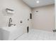 Bright laundry room featuring a modern sink, tiled floors, and neutral walls at 170 Sw 80Th St, Ocala, FL 34476