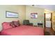 Bedroom with red bedding, accent chair, and a nearby laundry area at 20820 River Dr # B32, Dunnellon, FL 34431
