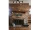 Close-up of the brick fireplace featuring mantle with a wooden decorative grate at 2151 Se 177Th Ave, Silver Springs, FL 34488