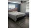 View of the main bedroom with a large bed, gray laminate floors, and two large windows at 2151 Se 177Th Ave, Silver Springs, FL 34488