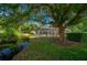 This backyard offers mature landscaping, a tranquil stream, and a screened lanai at 2272 Se Laurel Run Dr, Ocala, FL 34471