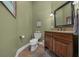 Powder room with stone countertops and dark wood cabinets and earth tone paint at 2272 Se Laurel Run Dr, Ocala, FL 34471