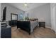 Bedroom features wood floors, a black bed and dresser, and a window with blinds at 2272 Se Laurel Run Dr, Ocala, FL 34471