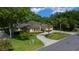 Charming single-story home with a circular driveway, lush landscaping, and mature trees providing ample shade at 2272 Se Laurel Run Dr, Ocala, FL 34471