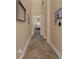 Hallway with ceramic floors, neutral paint and decor leads to a main bedroom at 2272 Se Laurel Run Dr, Ocala, FL 34471