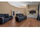 Living room featuring hardwood floors and comfortable couches with TV and built-in cabinets at 2272 Se Laurel Run Dr, Ocala, FL 34471