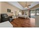 Spacious main bedroom with wood floors, large windows, a ceiling fan, and a seating area at 2272 Se Laurel Run Dr, Ocala, FL 34471