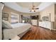 A bright main bedroom with light walls, wood floors, a ceiling fan, and large windows at 2272 Se Laurel Run Dr, Ocala, FL 34471