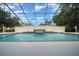 The beautiful tiled pool is surrounded by a wall with beautiful trees in the background at 2272 Se Laurel Run Dr, Ocala, FL 34471