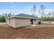 Backyard view of a single-story home showcasing a covered patio, lush lawn, and landscaping, perfect for outdoor entertaining at 23131 Sw Rainelle Rd, Dunnellon, FL 34431