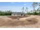 Large backyard of a single-story home, landscaped with fresh mulch and native trees, offering endless possibilities at 23131 Sw Rainelle Rd, Dunnellon, FL 34431