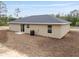 Exterior shot showcasing backyard and neutral color scheme of the single story home at 23131 Sw Rainelle Rd, Dunnellon, FL 34431
