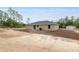Spacious lot showcasing a single-story home with a patio, surrounded by a lush lawn and mature trees, perfect for entertaining at 23131 Sw Rainelle Rd, Dunnellon, FL 34431