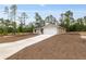 Well-maintained, single-story home with a long driveway and attached garage, surrounded by fresh landscaping and mature trees at 23131 Sw Rainelle Rd, Dunnellon, FL 34431