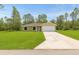 Charming single-story home with a two-car garage, lush lawn, and a neatly paved driveway at 23131 Sw Rainelle Rd, Dunnellon, FL 34431