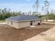 Back of single-story beige house featuring new landscaping, new roof, and pristine backyard at 23131 Sw Rainelle Rd, Dunnellon, FL 34431