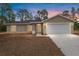 A single-Gathering home showcases a large garage, new landscaping, and a well-maintained lawn at 23131 Sw Rainelle Rd, Dunnellon, FL 34431