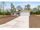 New construction home featuring a 2-car garage and a long driveway at 23131 Sw Rainelle Rd, Dunnellon, FL 34431