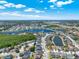 Scenic aerial view of a community featuring a lake and well-maintained homes under a bright, partly cloudy sky at 2525 Sand Arbor Cir, Orlando, FL 32824