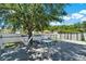Backyard deck with a glass table, complemented by a lush tree and white fencing at 2525 Sand Arbor Cir, Orlando, FL 32824