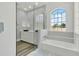 Bright bathroom showcasing double sinks, quartz counters, a tub, and a large arch window at 2525 Sand Arbor Cir, Orlando, FL 32824