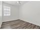 Bright bedroom featuring modern gray wood floors, a ceiling fan, and a window for natural light at 2525 Sand Arbor Cir, Orlando, FL 32824