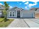 Inviting home featuring a two-car garage, elegant entrance, and manicured landscaping at 2525 Sand Arbor Cir, Orlando, FL 32824