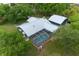 Overhead view of house featuring a screened-in pool, metal roof, and lush landscaping at 260 Country Circle W Dr, Port Orange, FL 32128