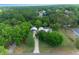Expansive aerial view of home nestled among lush trees, with a long driveway and separate garage at 260 Country Circle W Dr, Port Orange, FL 32128