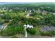 Aerial view of a home with a pool, set amidst lush trees and overlooking a tranquil pond at 260 Country Circle W Dr, Port Orange, FL 32128