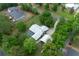 Aerial view showcases property with pool and detached garage amidst verdant landscape and other houses at 260 Country Circle W Dr, Port Orange, FL 32128