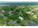 Aerial view showcases home with surrounding trees and greenery, near a lake and other homes at 260 Country Circle W Dr, Port Orange, FL 32128