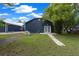 Lovely backyard with a walkway leading to double doors on a home with a well-manicured lawn at 260 Country Circle W Dr, Port Orange, FL 32128
