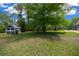 Spacious backyard with chicken coop, mature trees, and lush green grass at 260 Country Circle W Dr, Port Orange, FL 32128