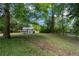 Expansive backyard with a charming chicken coop structure nestled amidst lush greenery and mature trees at 260 Country Circle W Dr, Port Orange, FL 32128