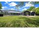 Large backyard boasts a screened-in pool, spacious lawn, and a beautifully designed dark blue house at 260 Country Circle W Dr, Port Orange, FL 32128