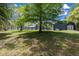 Large backyard featuring an enclosed patio, mature trees, and lush green grass at 260 Country Circle W Dr, Port Orange, FL 32128