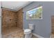 A bathroom showcasing a walk-in shower with tile surround, toilet, window, and ample natural light at 260 Country Circle W Dr, Port Orange, FL 32128