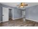 An empty bedroom with wood-look floors, a ceiling fan, and a closet with built-in shelving at 260 Country Circle W Dr, Port Orange, FL 32128