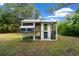 Close-up view of a well-maintained chicken coop featuring a metal roof and ample space for poultry at 260 Country Circle W Dr, Port Orange, FL 32128