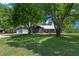 Home exterior with well-manicured lawn and mature shade trees at 260 Country Circle W Dr, Port Orange, FL 32128