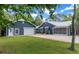 Charming home with a spacious driveway, lush lawn, and a detached garage, perfect for extra parking and storage at 260 Country Circle W Dr, Port Orange, FL 32128