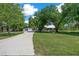 Serene view of a home featuring a neatly kept lawn, a winding driveway, and an adjacent detached garage at 260 Country Circle W Dr, Port Orange, FL 32128