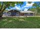 Attractive single-story home featuring a well-kept lawn, rock landscaping, and a metal roof at 260 Country Circle W Dr, Port Orange, FL 32128