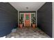 Inviting front porch featuring a vibrant orange door framed by elegant topiaries and a decorative, tiled walkway at 260 Country Circle W Dr, Port Orange, FL 32128