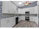 A kitchen featuring white cabinets, stainless steel appliances, mosaic backsplash, and a skylight at 260 Country Circle W Dr, Port Orange, FL 32128