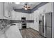 A well-lit kitchen featuring white cabinets, quartz counters, stainless steel appliances, and hardwood floors at 260 Country Circle W Dr, Port Orange, FL 32128