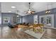 Spacious living area featuring wood-look flooring, modern furniture, and an open floor plan including the kitchen and dining area at 260 Country Circle W Dr, Port Orange, FL 32128