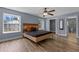 A primary bedroom featuring wood floors, light blue walls, and two windows offering views of the exterior at 260 Country Circle W Dr, Port Orange, FL 32128